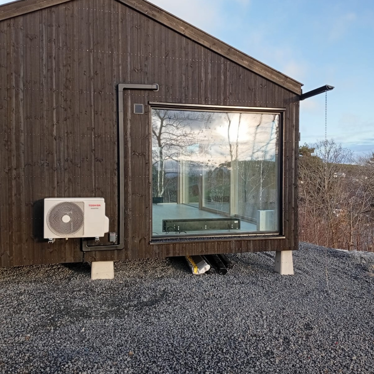 Svart rörkanalkåpa på svart träpanel
